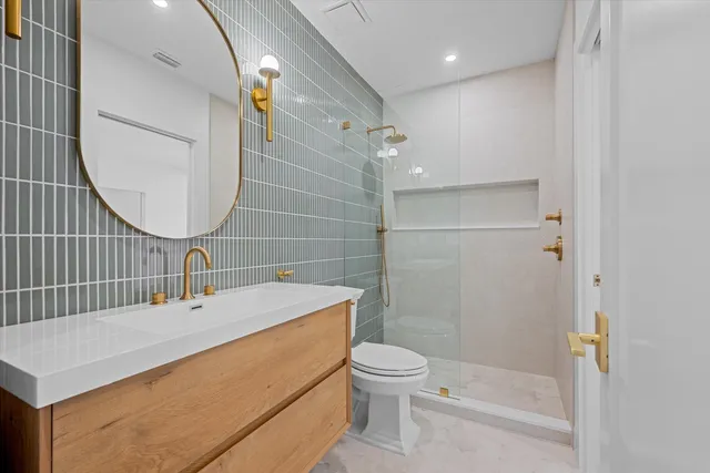 a bathroom with a sink a toilet and shower