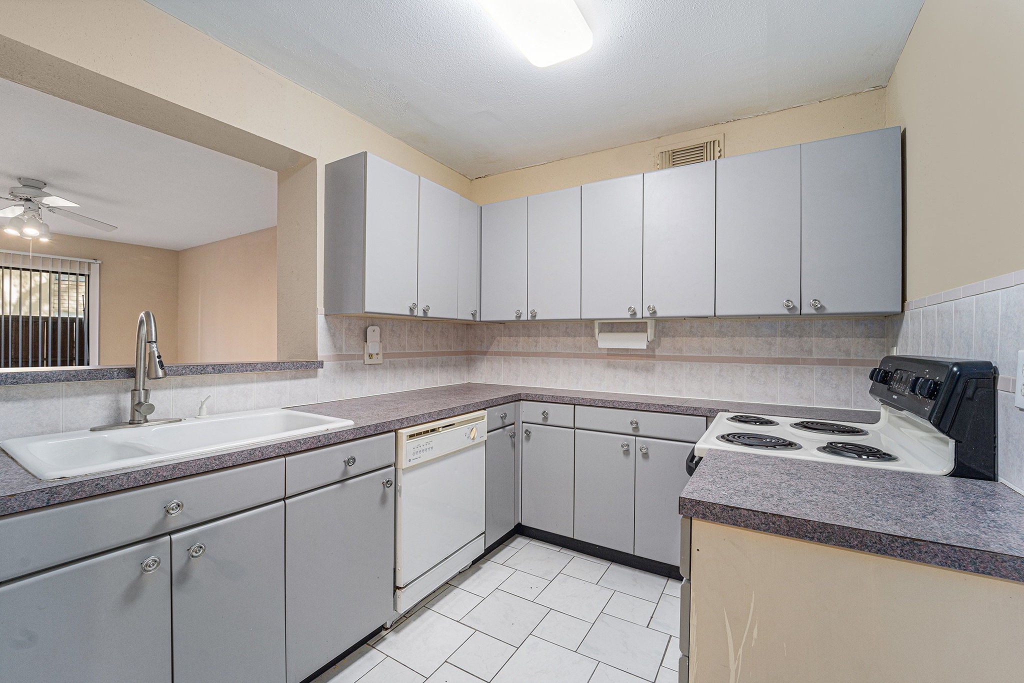 3300 Pebblebrook Drive, Unit 75 Seabrook, TX 77586 - Photo 7 of 30 a kitchen with sink cabinets and window
