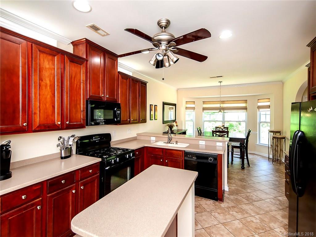 284 Sand Paver Way Fort Mill, SC 29708 - Photo 9 of 24 a kitchen with a stove a sink a dining table and chairs