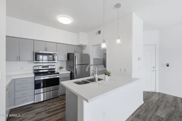 a kitchen with kitchen island a sink stainless steel appliances and cabinets