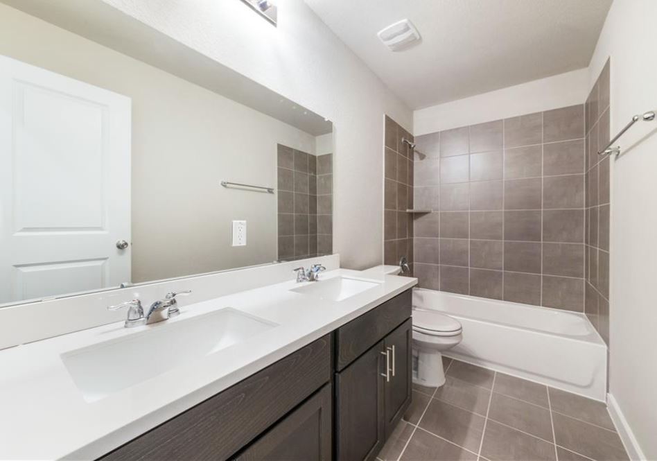 2221 Rocoso Trail Leander, TX 78641 - Photo 13 of 16 Bathroom with shower / bathtub combination, double vanity, and dark tile patterned floors