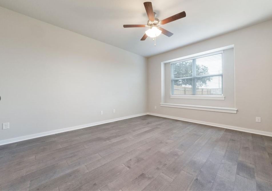 2221 Rocoso Trail Leander, TX 78641 - Photo 6 of 16 Empty room with dark wood-style flooring and ceiling fan
