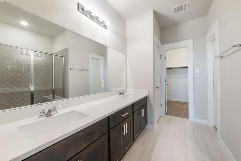 2221 Rocoso Trail Leander, TX 78641 - Photo 9 of 16 Full bath featuring double vanity, a shower stall, and a spacious closet