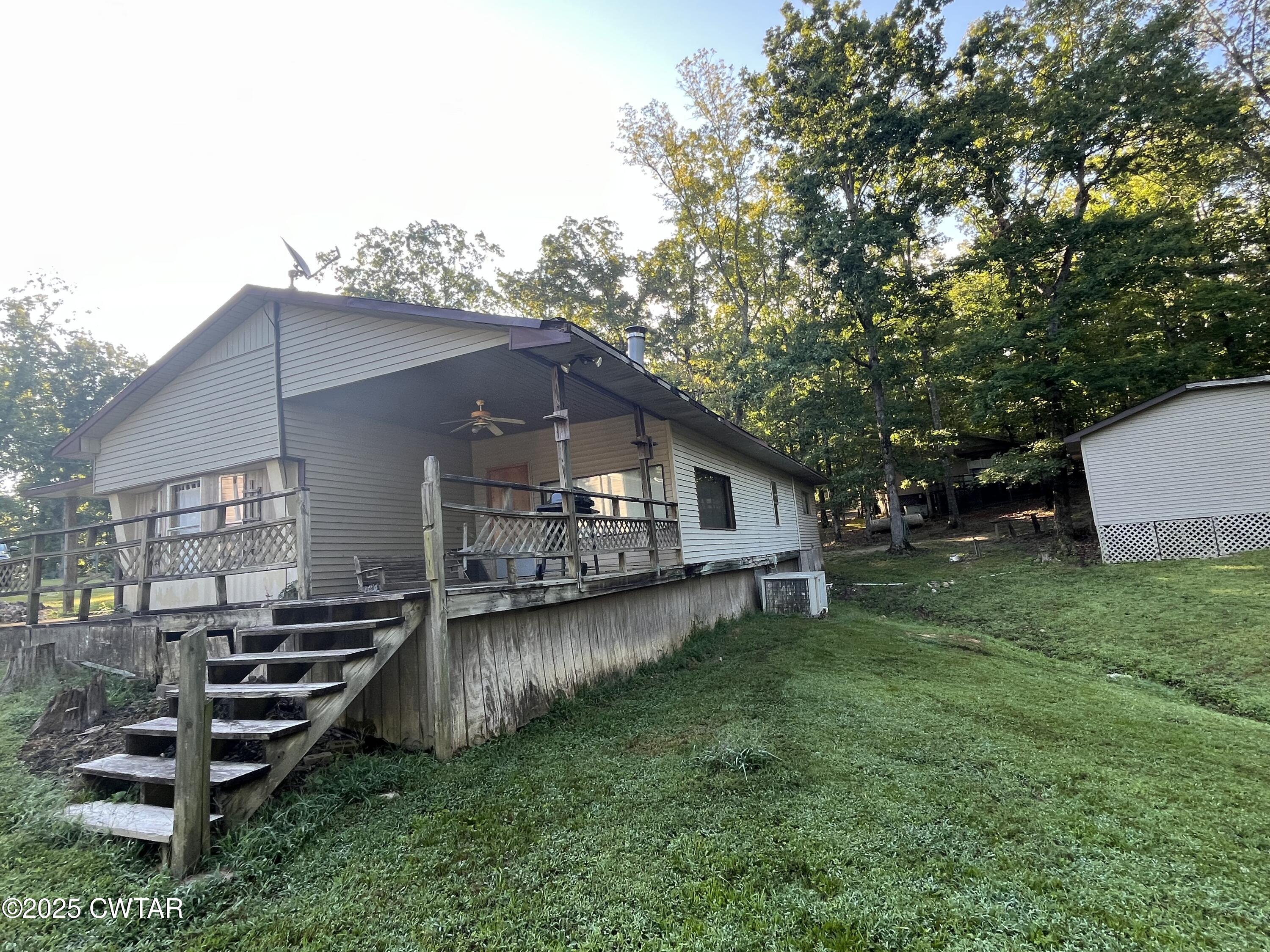 294 Ridgeway Road Sugar Tree, TN 38380 - Photo 8 of 34 a wooden house with a yard and large trees