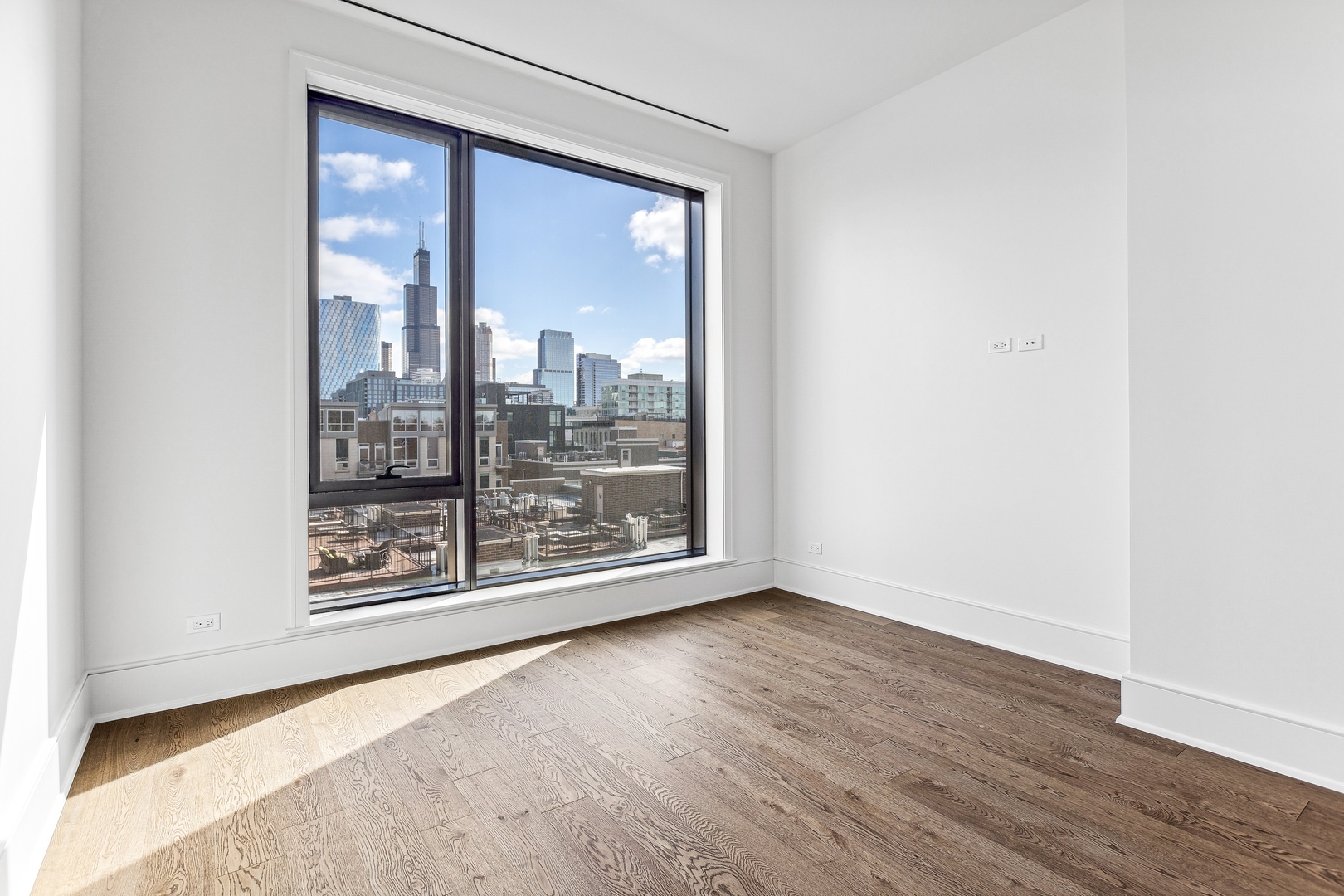 21 North May Street, Unit 601 Chicago, IL 60607 - Photo 54 of 64 a view of an empty room with wooden floor and a window
