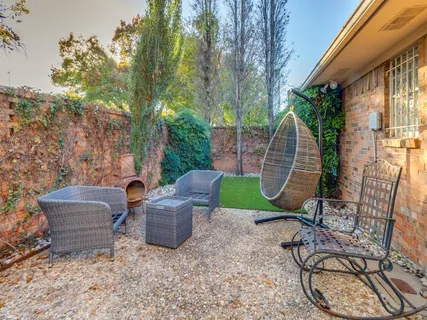 a view of a chair and table in backyard of the house