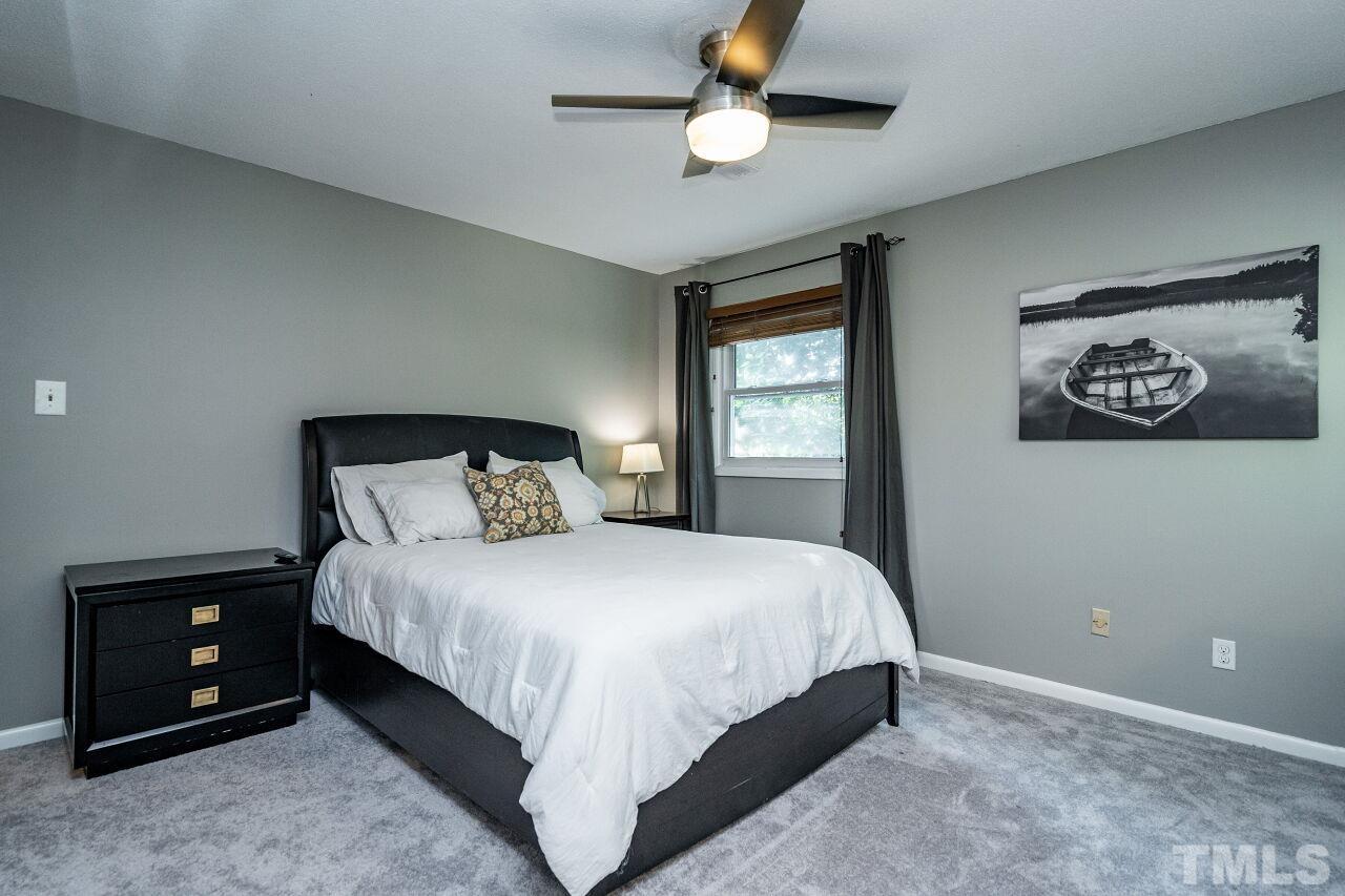 1500 Windbur Place Raleigh, NC 27609 - Photo 11 of 30 a bedroom with a bed and a ceiling fan
