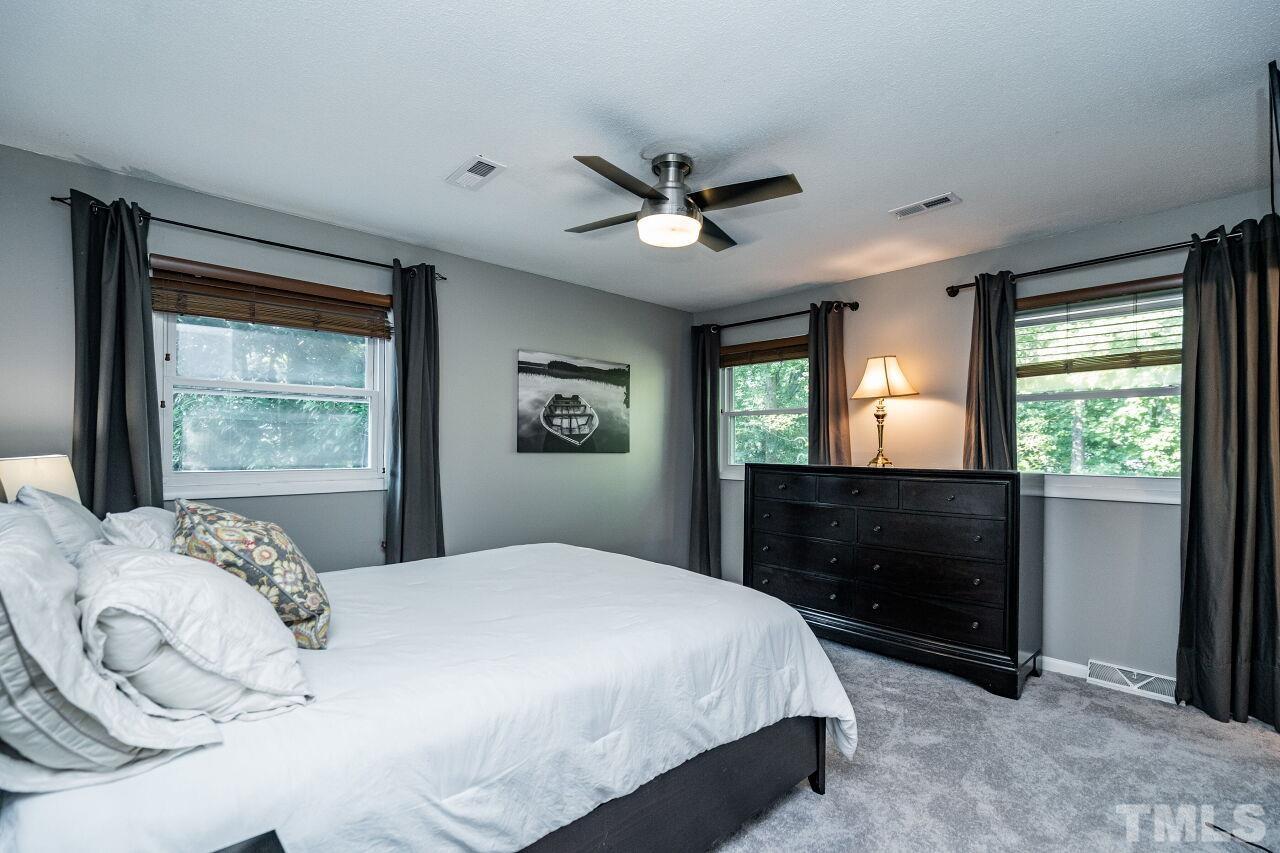1500 Windbur Place Raleigh, NC 27609 - Photo 12 of 30 a bedroom with a bed and a dresser next to a window