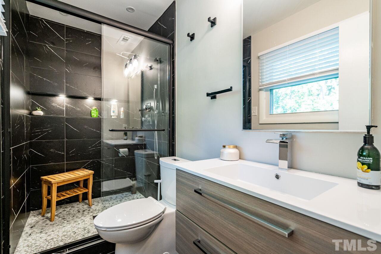 1500 Windbur Place Raleigh, NC 27609 - Photo 13 of 30 a bathroom with a sink a toilet and shower