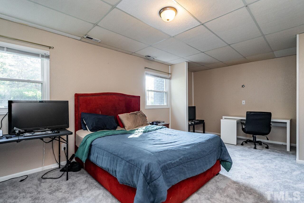 1500 Windbur Place Raleigh, NC 27609 - Photo 21 of 30 a bed room with a bed and a chair