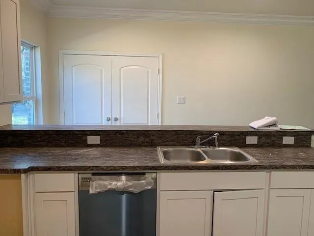 a kitchen with granite countertop white cabinets and a sink