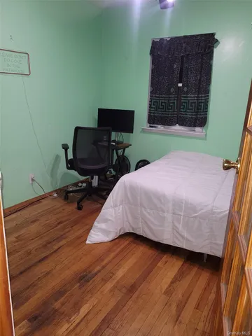 a bedroom with a bed window and a table in it
