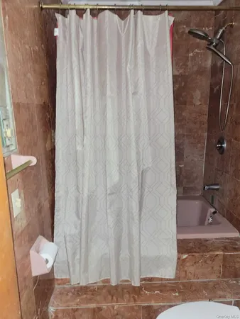 a bathroom with a granite countertop shower and a toilet