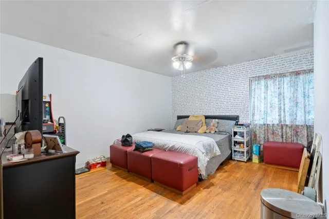 a spacious bedroom with a bed and wooden floor