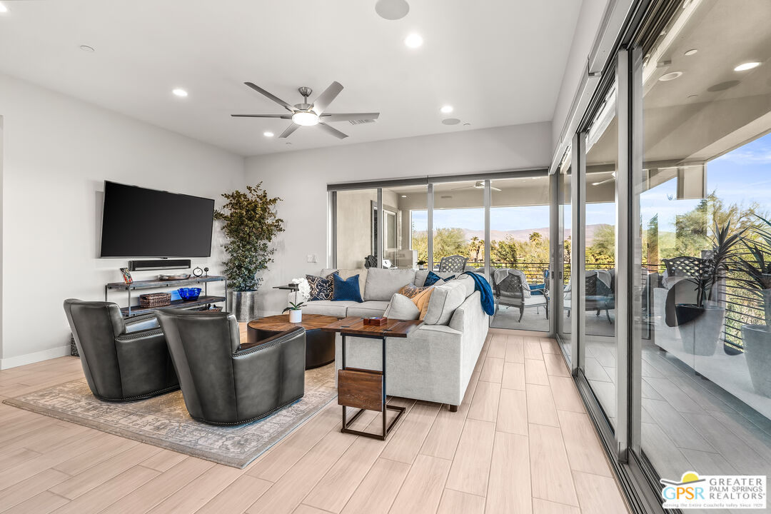 204 Retreat Circle Palm Desert, CA 92260 - Photo 16 of 60 a living room with furniture a flat screen tv and a floor to ceiling window