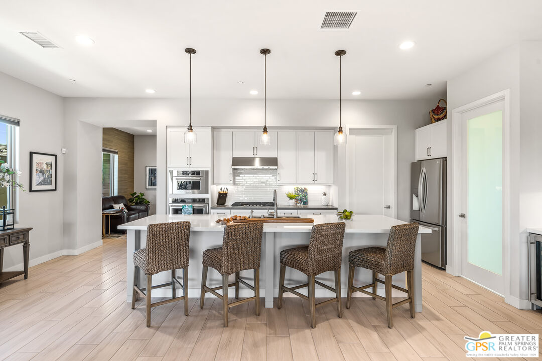 204 Retreat Circle Palm Desert, CA 92260 - Photo 24 of 60 a kitchen with stainless steel appliances kitchen island granite countertop a dining table chairs and granite counter tops