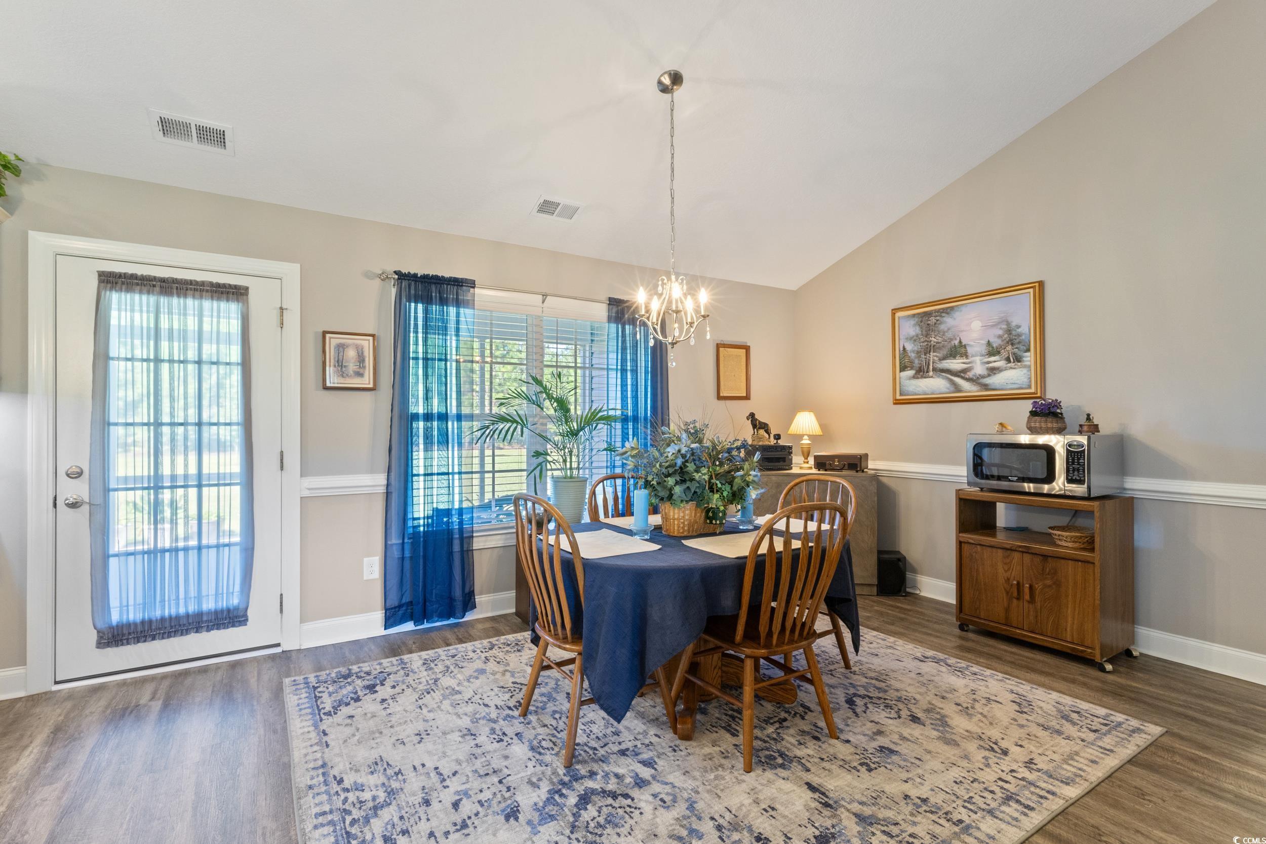 1353 Hucks Road Aynor, SC 29511 - Photo 15 of 40 Dining space featuring dark wood-style floors, vaulted ceiling, and a chandelier