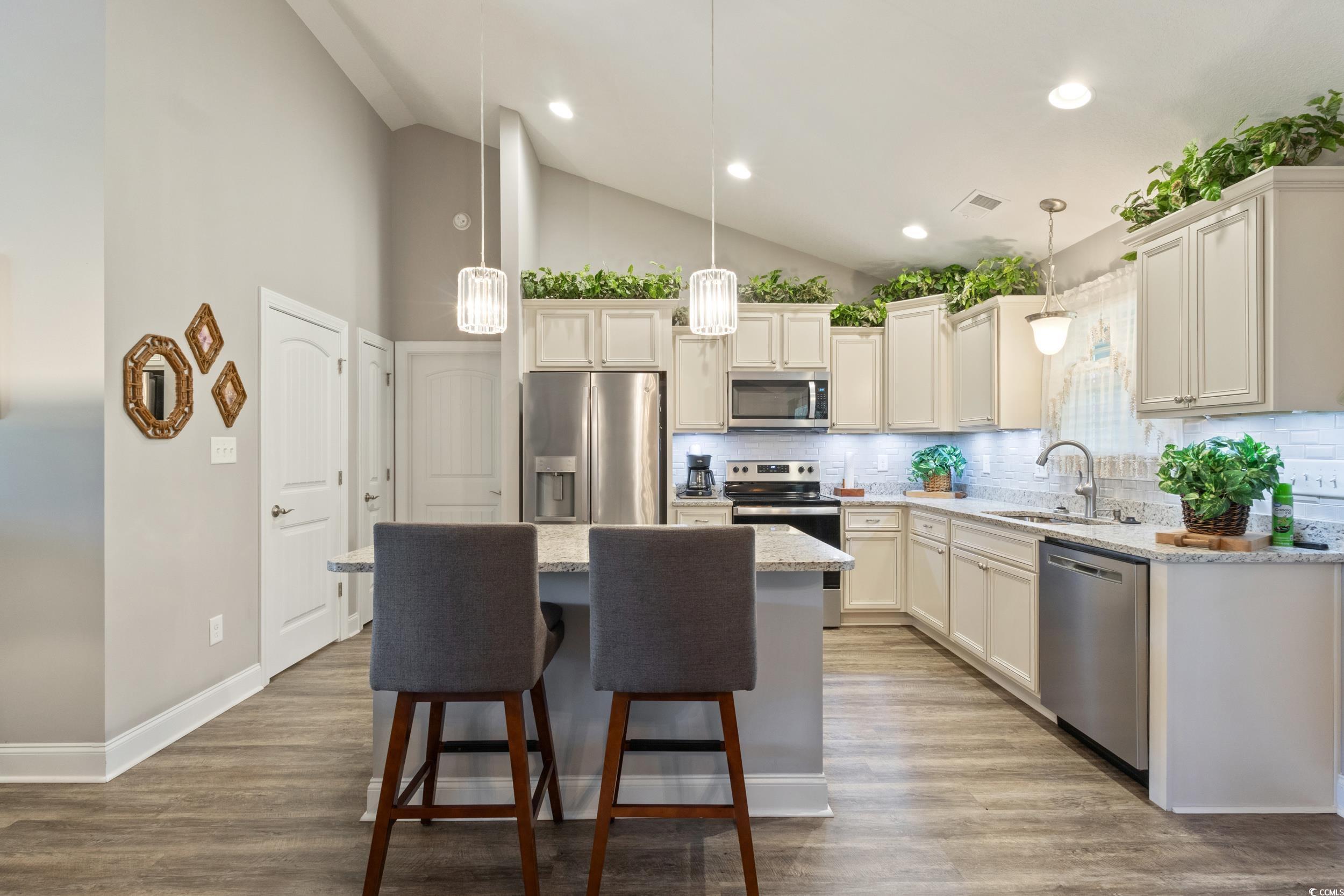 1353 Hucks Road Aynor, SC 29511 - Photo 17 of 40 Kitchen featuring tasteful backsplash, appliances with stainless steel finishes, hanging light fixtures, high vaulted ceiling, and dark wood-style flooring