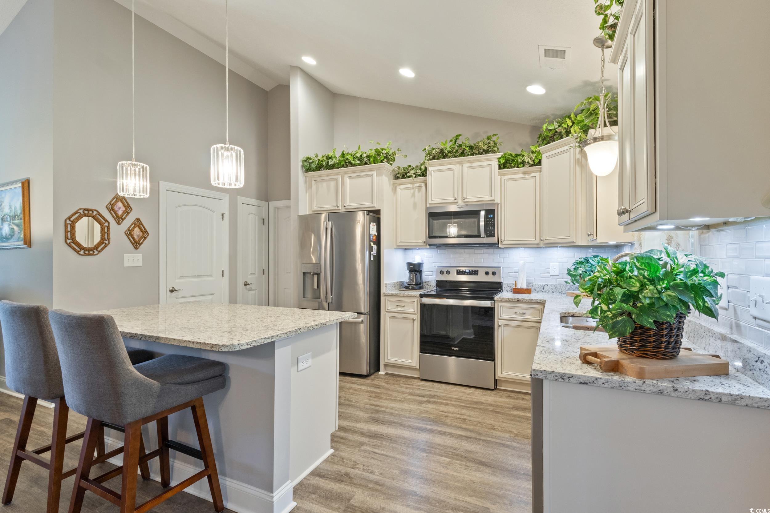 1353 Hucks Road Aynor, SC 29511 - Photo 18 of 40 Kitchen with pendant lighting, tasteful backsplash, stainless steel appliances, a kitchen bar, and light stone countertops