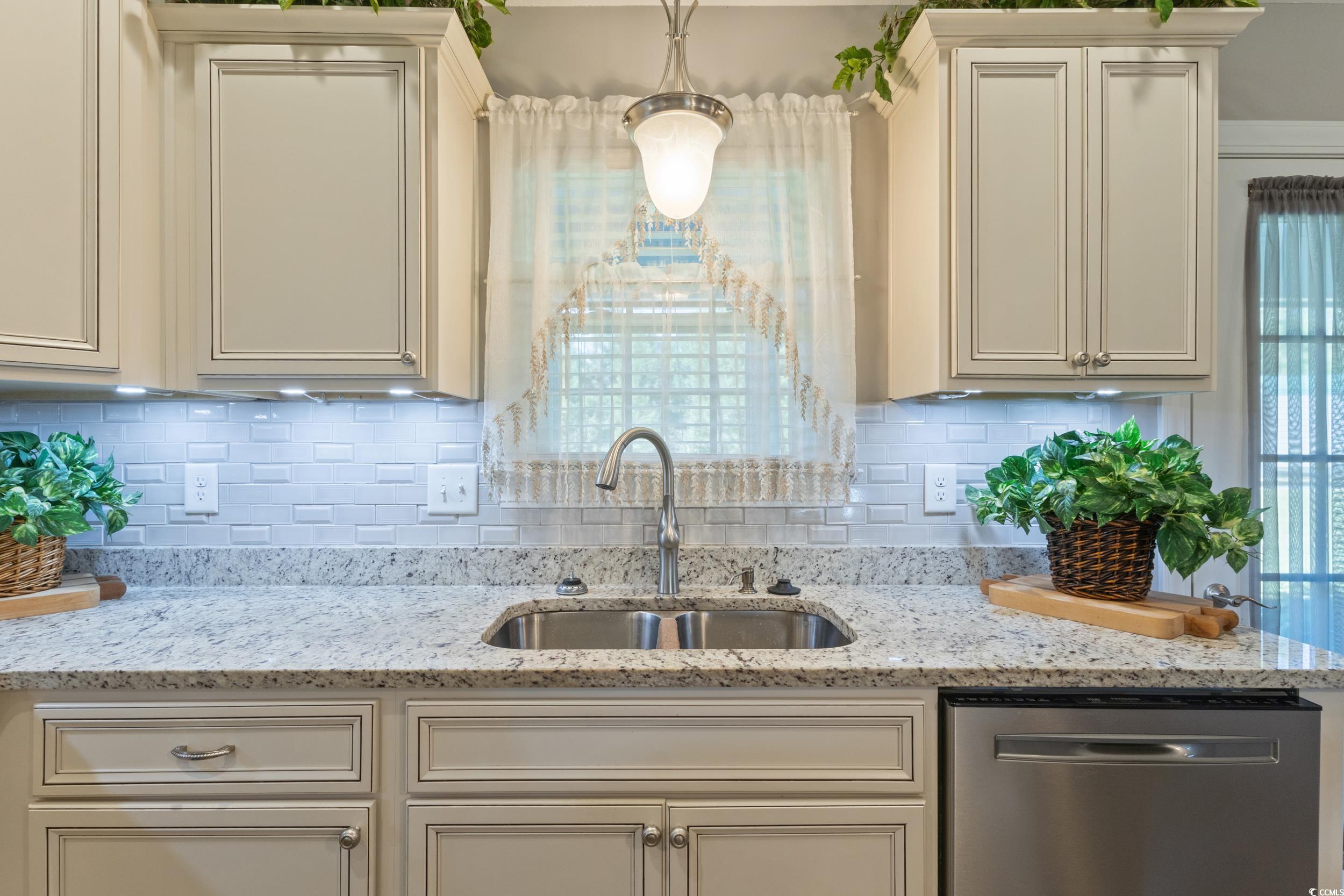 1353 Hucks Road Aynor, SC 29511 - Photo 19 of 40 Kitchen featuring stainless steel dishwasher, light stone countertops, decorative backsplash, and cream cabinetry