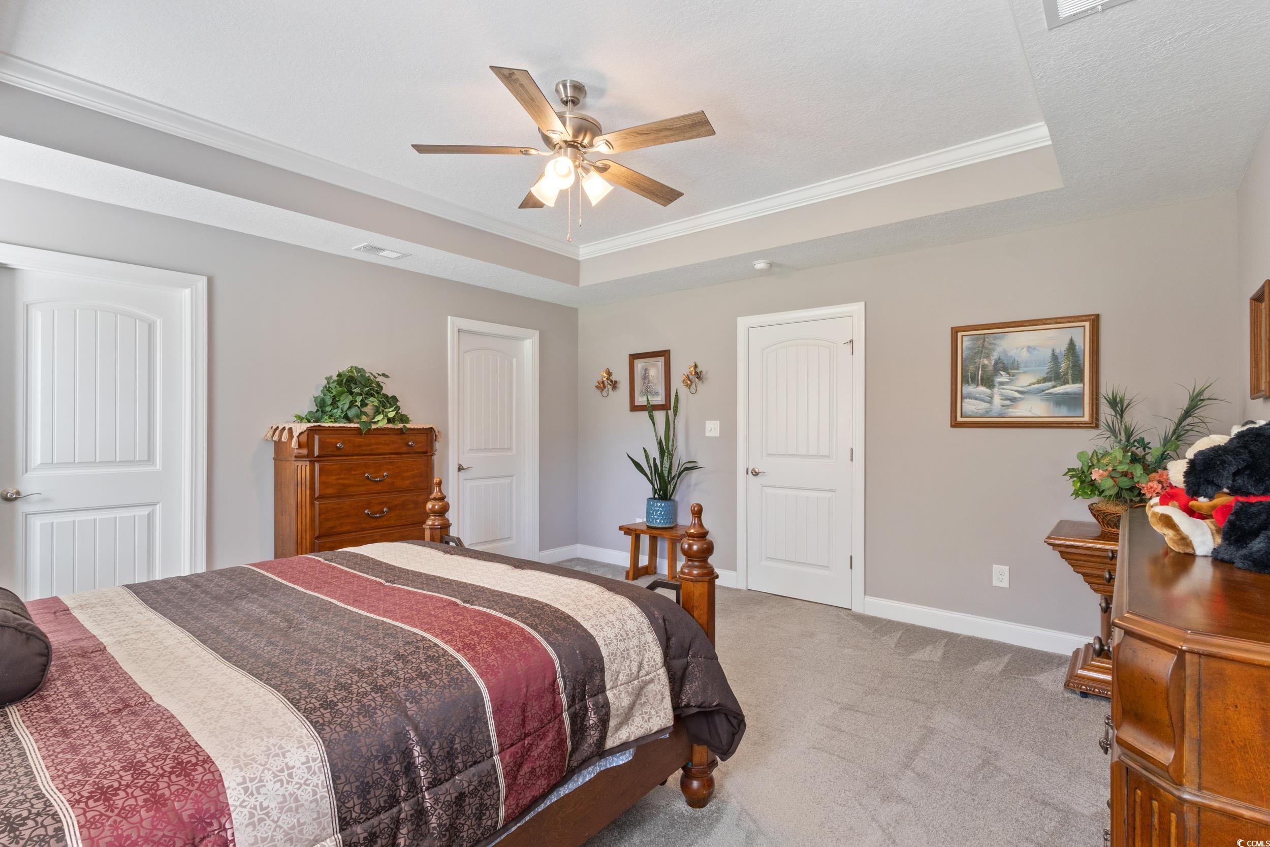 1353 Hucks Road Aynor, SC 29511 - Photo 23 of 40 Carpeted bedroom featuring a raised ceiling, crown molding, and ceiling fan