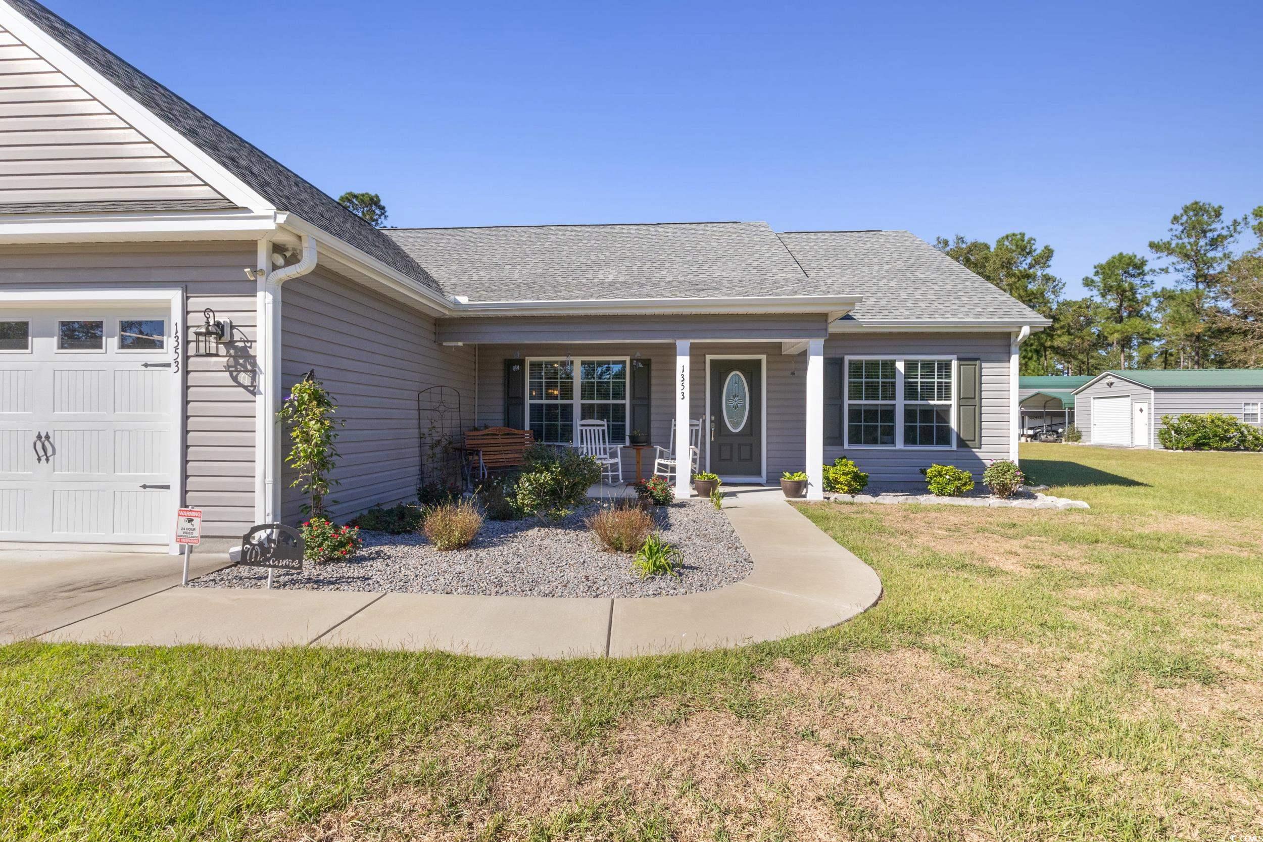 1353 Hucks Road Aynor, SC 29511 - Photo 7 of 40 View of front of home featuring a front lawn, roof with shingles, a porch, and a garage