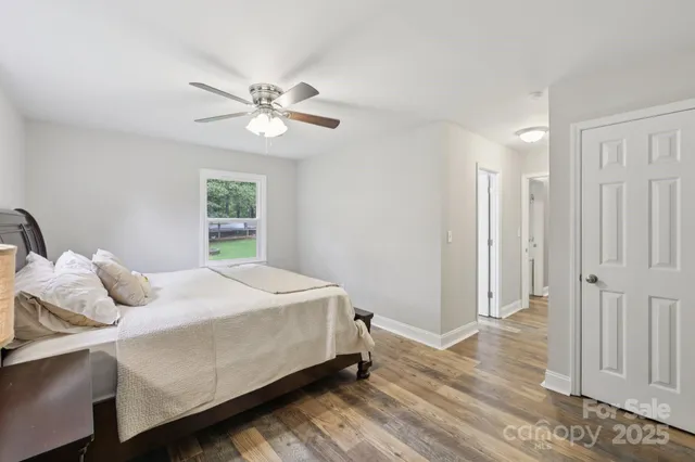 a bathroom with a granite countertop sink a toilet a mirror and a window