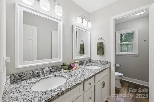 a en suite bathroom with a granite countertop sink and a mirror