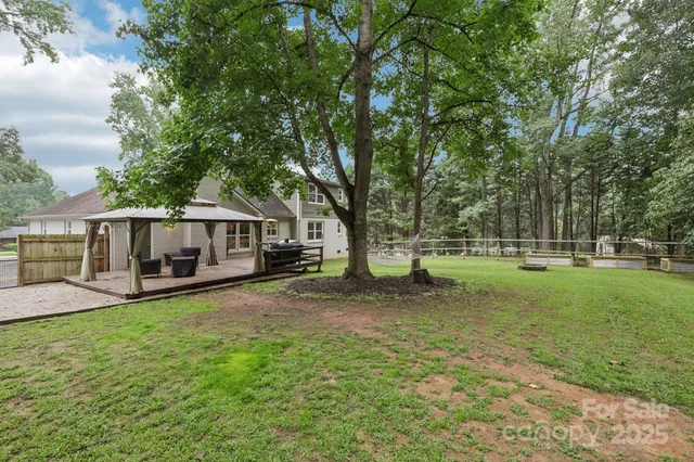 a front view of a house with a garden and trees