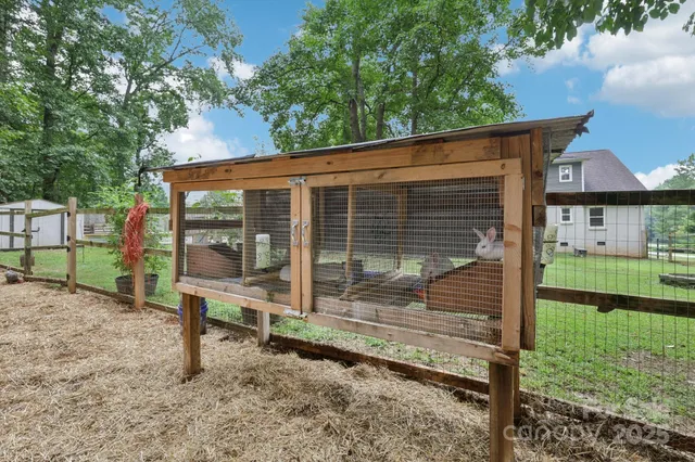 a view of a wooden house with a yard and outdoor seating