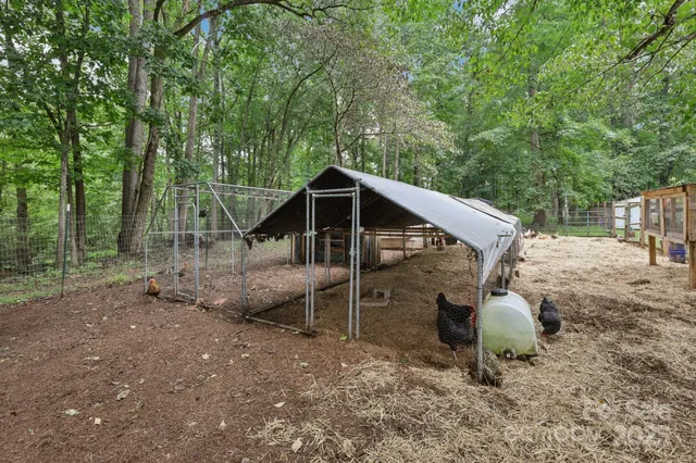 a view of a backyard with table and chairs and wooden fence