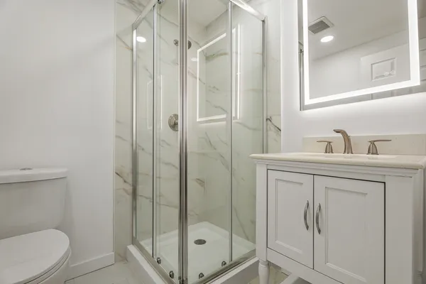 a bathroom with a shower a toilet and sink