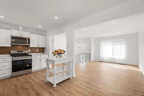 a kitchen with granite countertop a stove a sink and a microwave