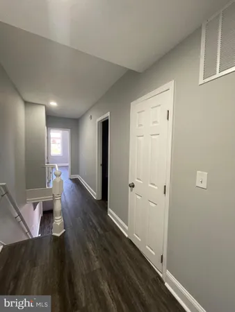 a view of a hallway with wooden floor and furniture