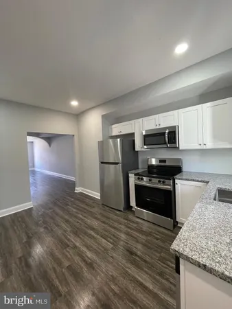 a kitchen with stainless steel appliances granite countertop a refrigerator stove and microwave