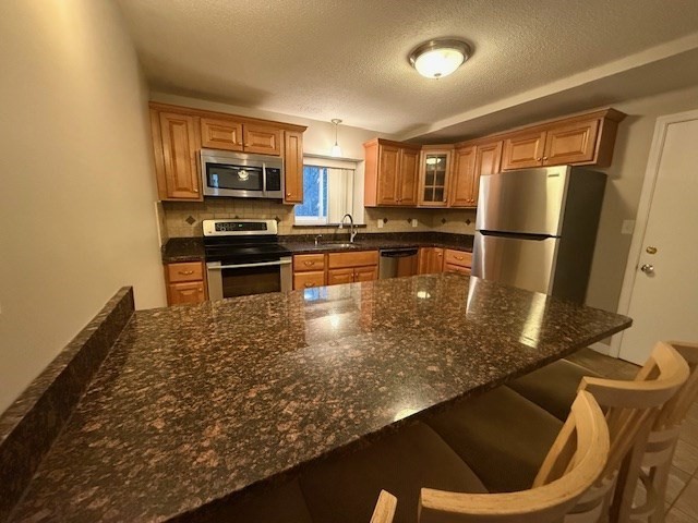 5455 North Main Street, Unit 12A Fall River, MA 02720 - Photo 4 of 16 a kitchen with stainless steel appliances granite countertop a refrigerator a stove and a sink with wooden floor