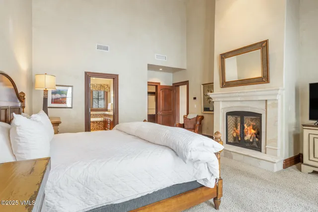 a spacious bedroom with a bed and a fireplace