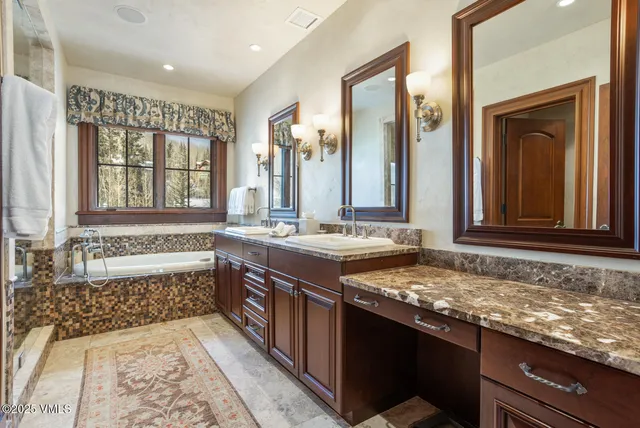 a bathroom with a granite countertop sink and a bathtub
