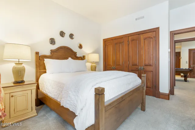 a bedroom with a bed and a lamp on dresser