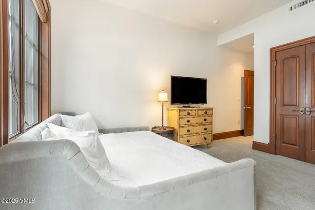 a bedroom with a bed and a flat screen tv