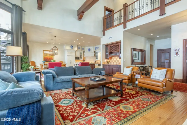 a living room with furniture kitchen view and a table