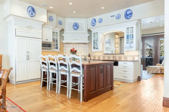 a kitchen with stainless steel appliances kitchen island granite countertop a table and chairs in it