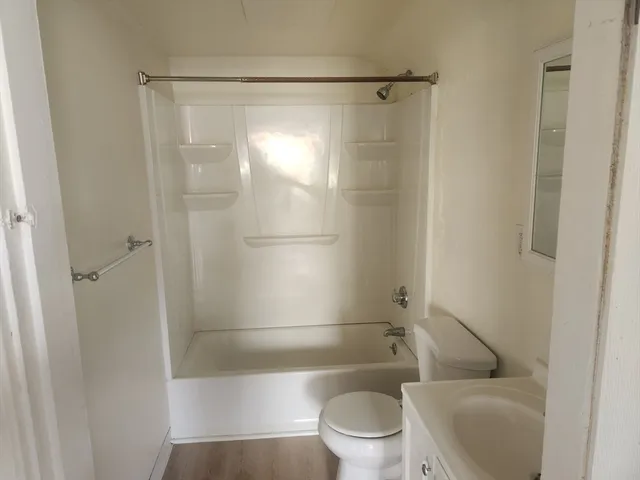 a white toilet sitting next to a bath tub