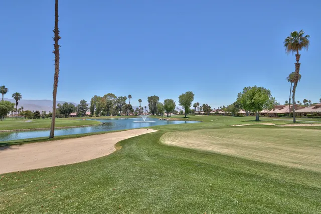 a view of a backyard with table and chairs under an umbrella