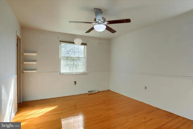 a view of a big room with wooden floor and windows in a room