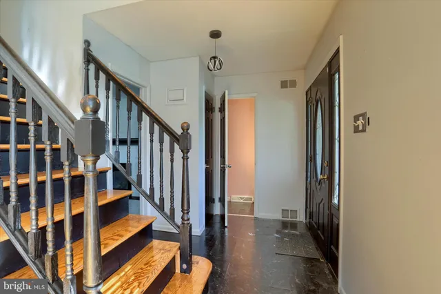 a view of staircase with lots of frames on wall and a window