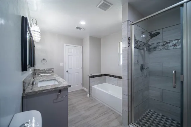 a bathroom with double vanity sinks granite vanity and a mirror