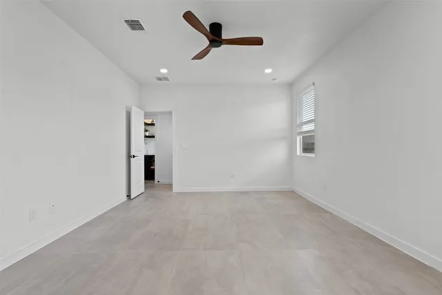 an empty room with closet and a ceiling fan