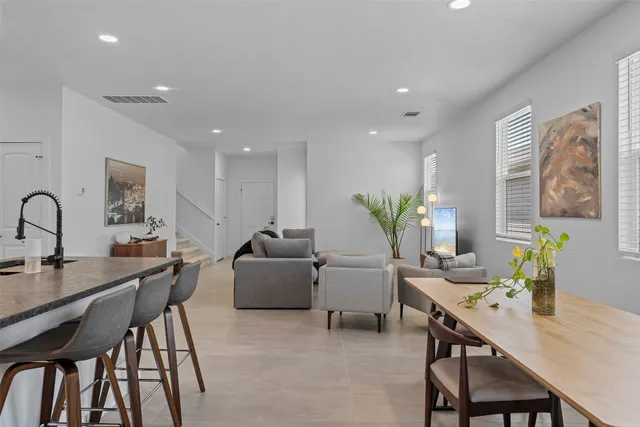 a living room with furniture kitchen view and a potted plant
