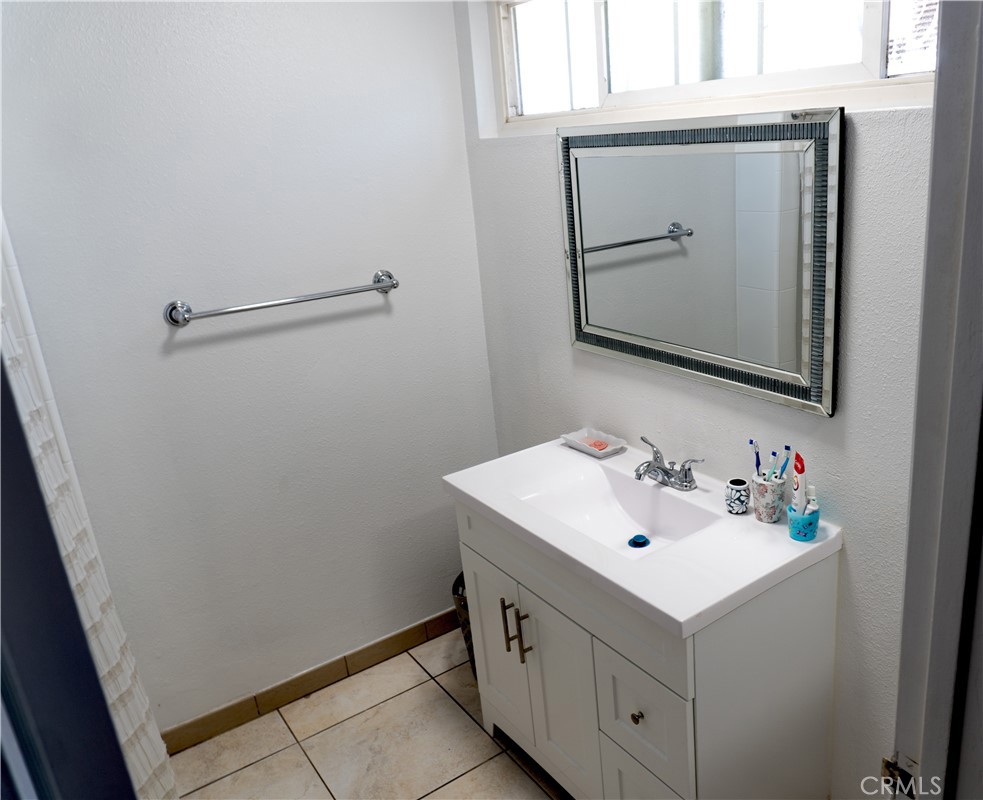 14802 Newport Avenue, Unit 2B Tustin, CA 92780 - Photo 11 of 13 a bathroom with a sink vanity and mirror